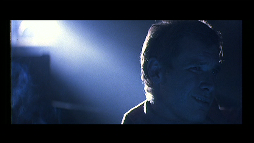 Deckard smirks in a smoke-filled projection room